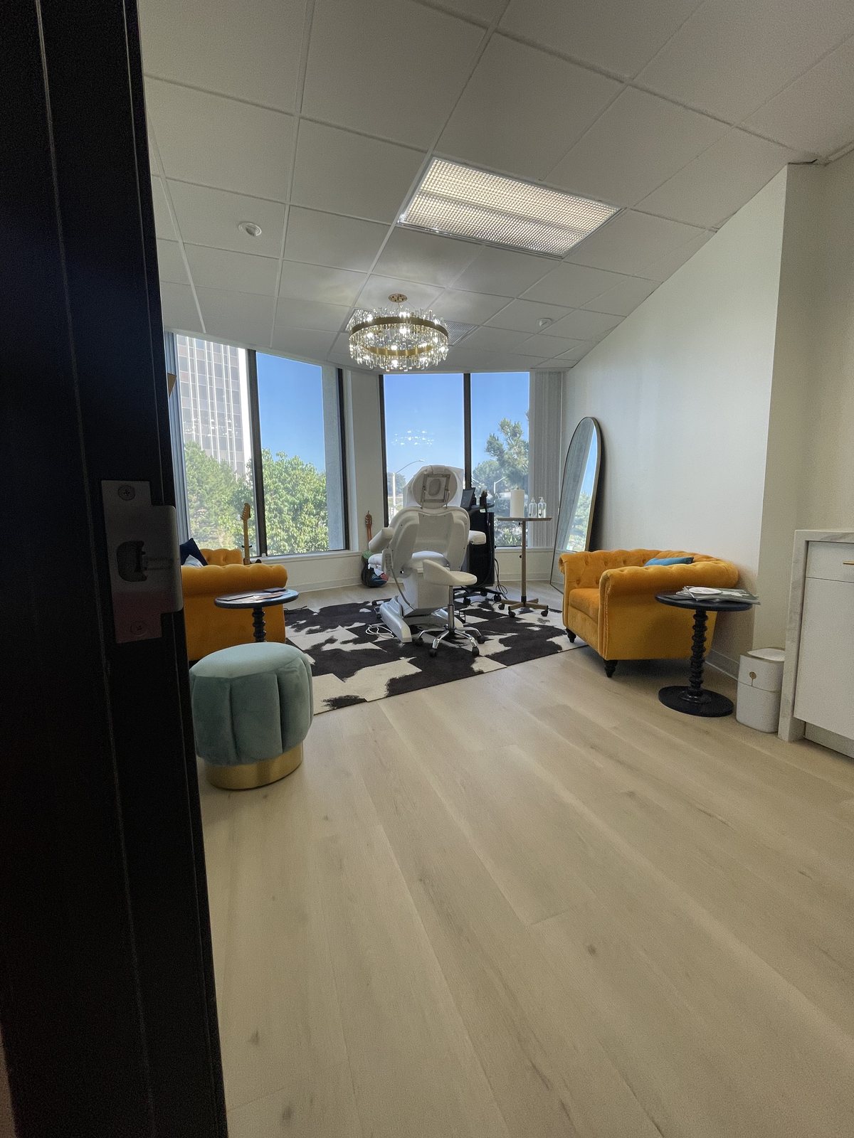 A Primary Care 4 Hair treatment room in Newport Beach with a corner window, treatment chair and seating